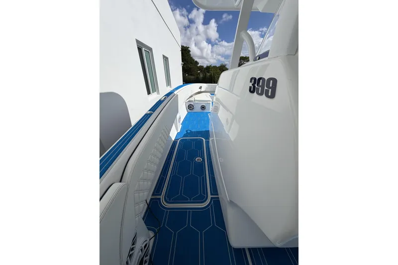 Slide: The Image of 2012 Deep Impact 399 Sport boat with blue deck, white seating, and modern design. - 10