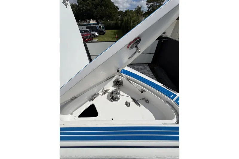 Slide: The Image of Open storage compartment on 2012 Deep Impact 399 Sport boat, featuring blue accents. - 13