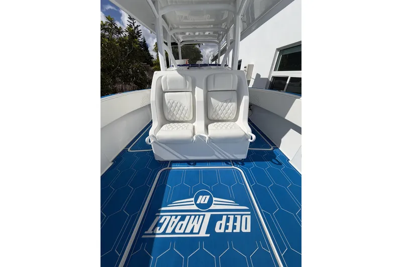 Slide: The Image of 2012 Deep Impact 399 Sport boat interior with white seats and blue flooring. - 14