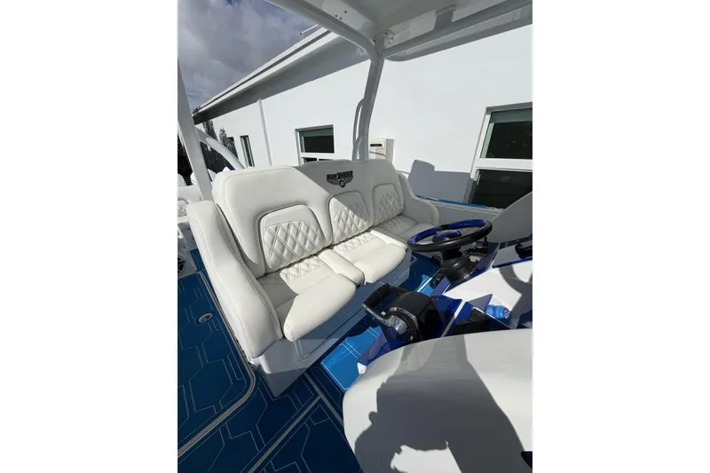 Slide: The Image of 2012 Deep Impact 399 Sport boat interior with white leather seating and blue accents. - 16