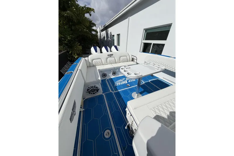 Slide: The Image of 2012 Deep Impact 399 Sport boat interior with blue and white seating and table. - 17