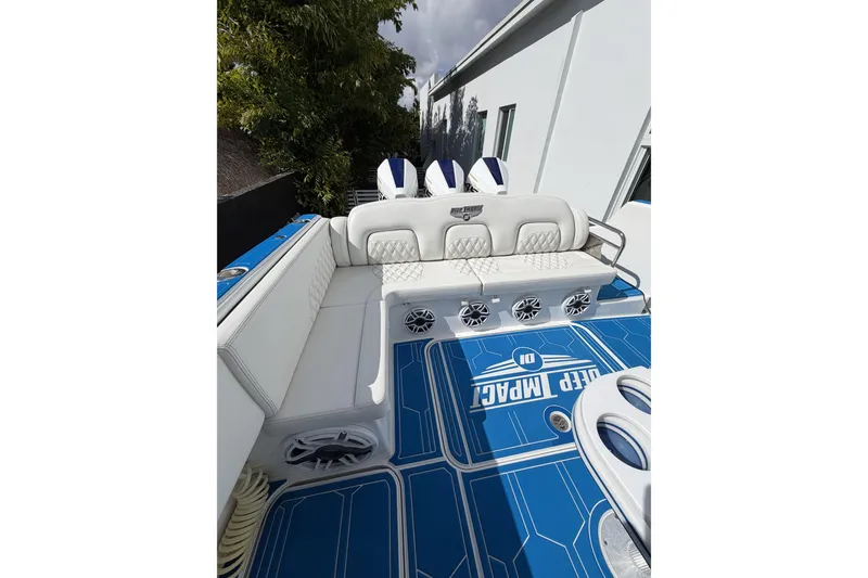 Slide: The Image of 2012 Deep Impact 399 Sport boat interior with blue flooring and white seating. - 18