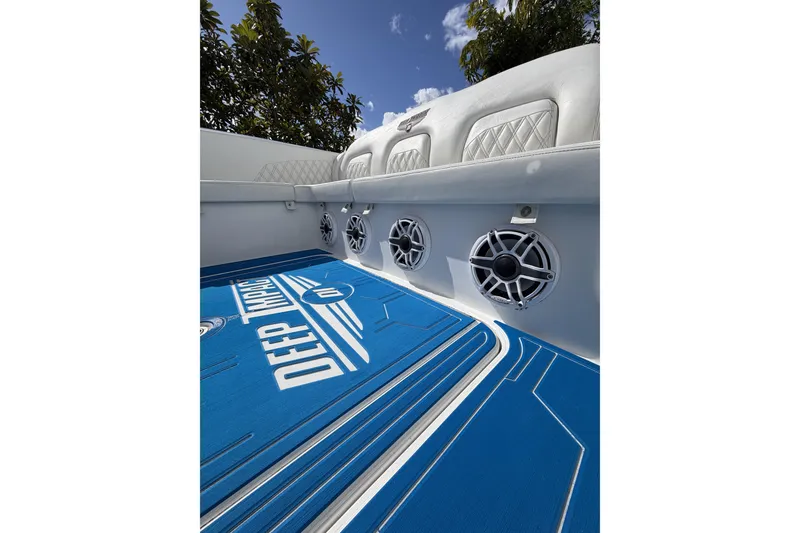 Slide: The Image of Interior of 2012 Deep Impact 399 Sport boat with blue flooring and speakers. - 19