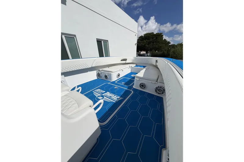 Slide: The Image of 2012 Deep Impact 399 Sport boat interior with blue flooring and white seating. - 21