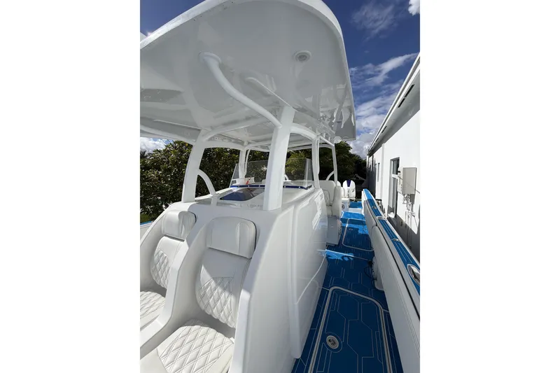 Slide: The Image of 2012 Deep Impact 399 Sport boat interior with white seating and blue flooring. - 23