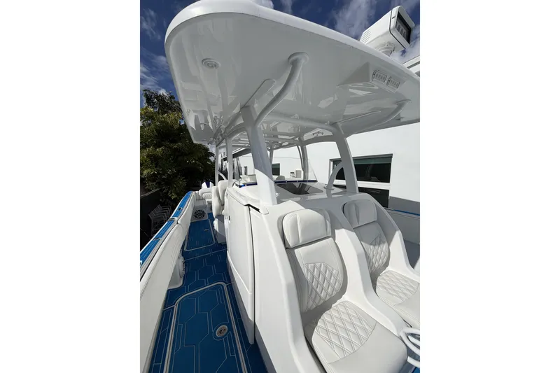 Slide: The Image of 2012 Deep Impact 399 Sport boat with sleek white seating and blue deck. - 24