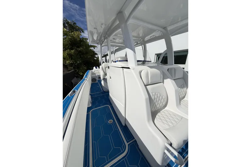 Slide: The Image of 2012 Deep Impact 399 Sport boat with white seating and blue deck. - 25