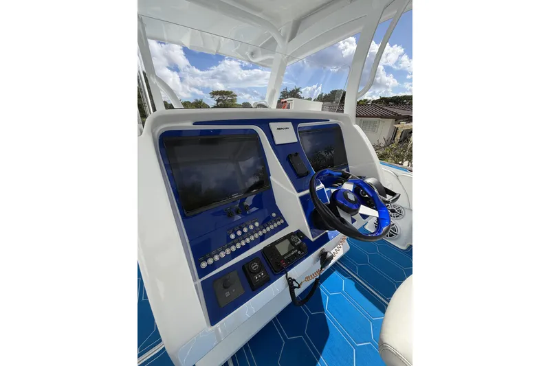 Slide: The Image of 2012 Deep Impact 399 Sport boat dashboard with blue accents and modern controls. - 4
