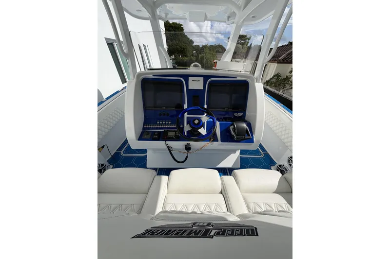 Slide: The Image of 2012 Deep Impact 399 Sport boat cockpit with modern controls and white seating. - 5