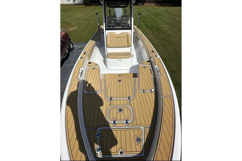 Slide: The Image of 2023 Sportsman Masters 267 Bay Boat with tan deck and seating, parked on grass. - 7