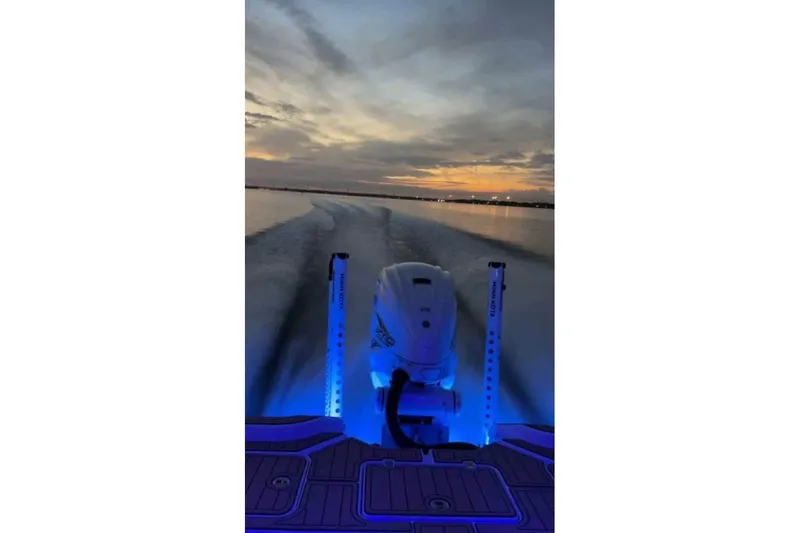 Slide: The Image of 2023 Sportsman Masters 267 Bay Boat cruising at sunset with illuminated deck. - 12