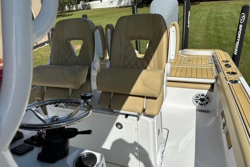 Slide: The Image of 2023 Sportsman Masters 267 Bay Boat interior with tan seats and steering wheel. - 10
