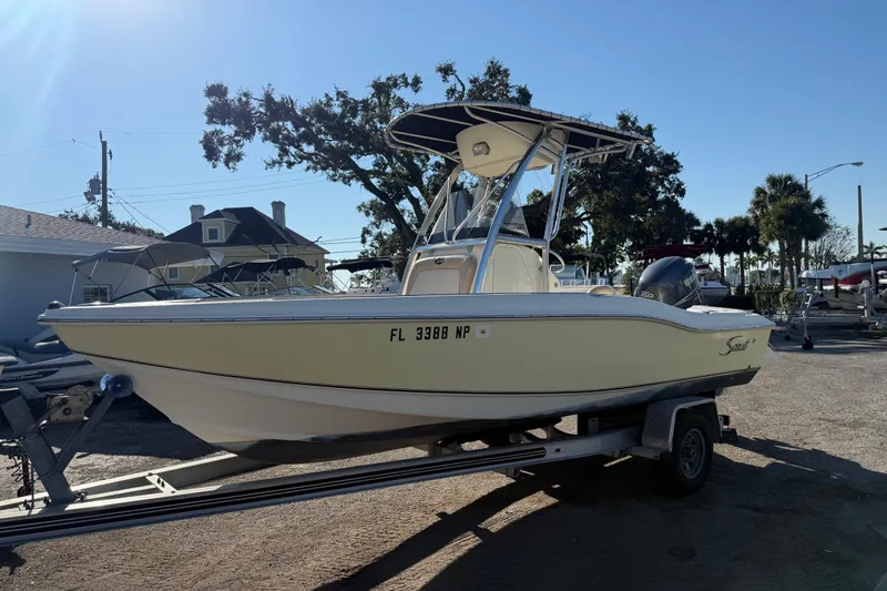 The Image of 2008 Scout 205 Sportfish boat on trailer, parked outdoors under clear sky. - 0