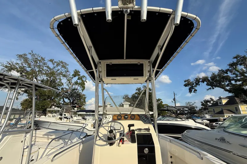 Slide: The Image of 2008 Scout 205 Sportfish boat interior with steering wheel and canopy, parked outdoors. - 13