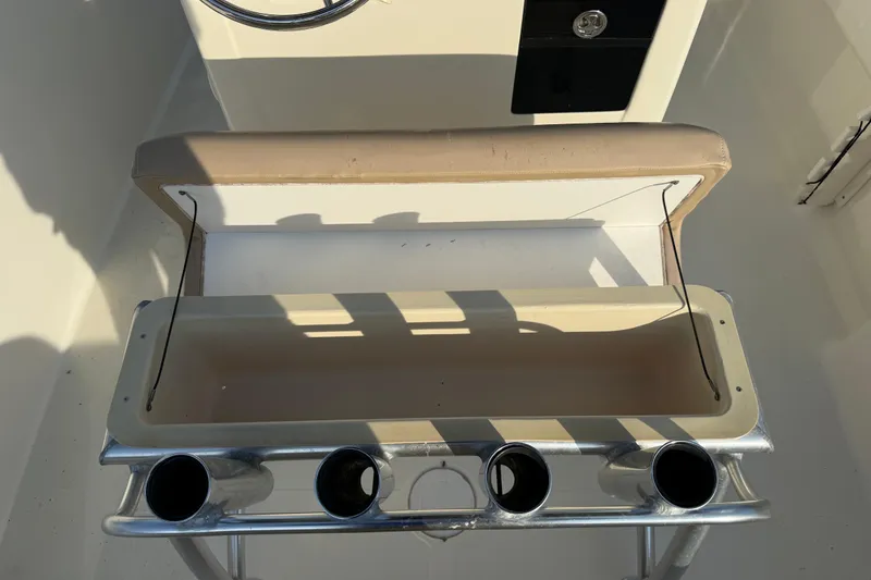 Slide: The Image of Open storage compartment on a 2008 Scout 205 Sportfish boat with rod holders. - 16