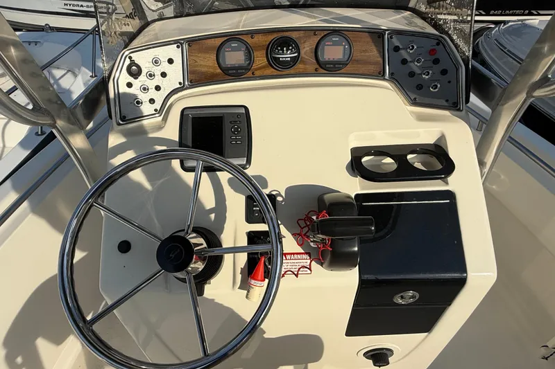 Slide: The Image of 2008 Scout 205 Sportfish boat dashboard with steering wheel and control panel. - 17