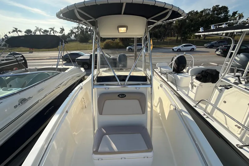 Slide: The Image of 2008 Scout 205 Sportfish boat with T-top and seating, parked at a marina. - 26