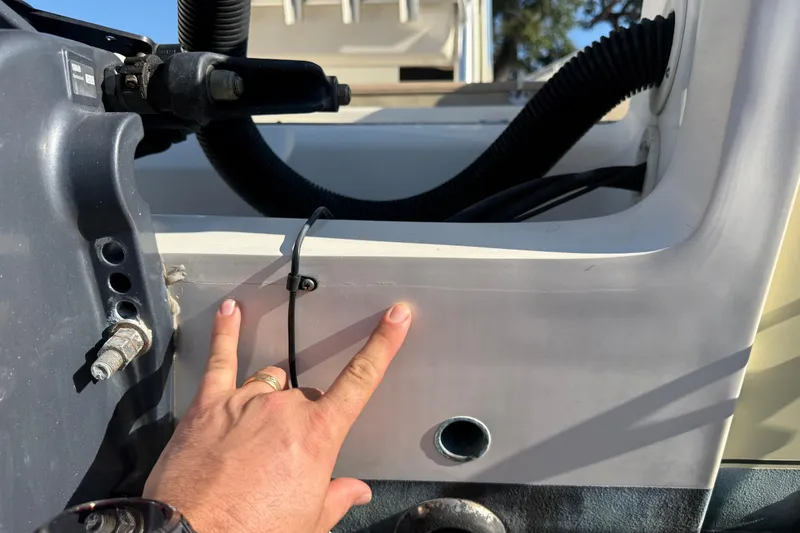 Slide: The Image of Close-up of a 2008 Scout 205 Sportfish boat detail with a hand pointing. - 31