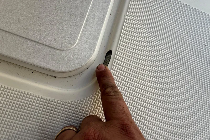 Slide: The Image of Close-up of a 2008 Scout 205 Sportfish boat deck with finger pointing at detail. - 9