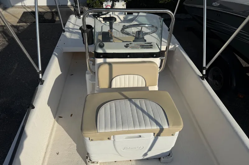 Slide: The Image of 2018 Sundance K16CC boat interior with steering console and cushioned seating. - 14