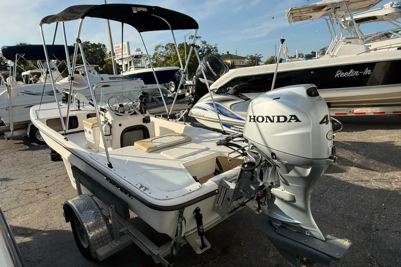 Slide: The Image of 2018 Sundance K16CC boat with Honda outboard motor, parked on a trailer. - 3