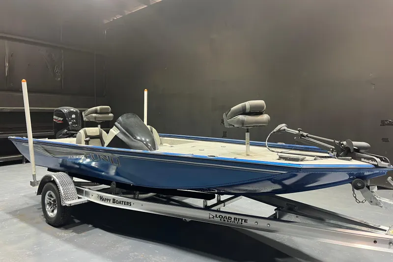 The Image of 2021 Lund 1875 Renegade fishing boat on trailer in a showroom. - 1