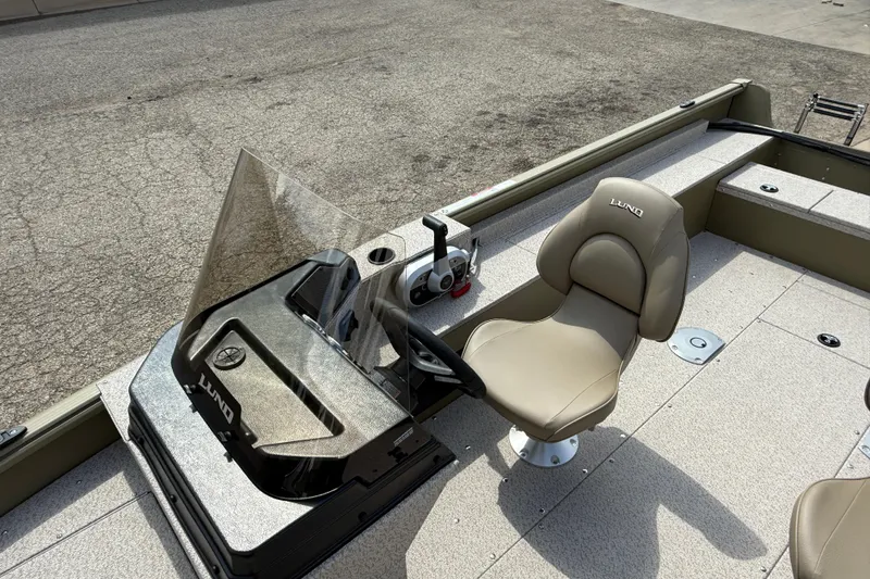 Slide: The Image of 2025 Lund 1875 Alaskan SS boat interior with steering console and cushioned seat. - 16