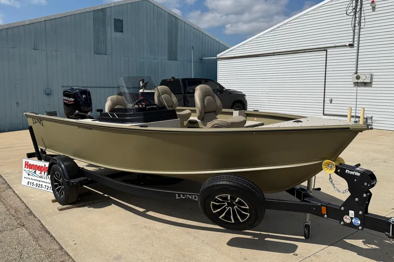 Slide: The Image of 2025 Lund 1875 Alaskan SS boat on trailer, parked outdoors near industrial buildings. - 2