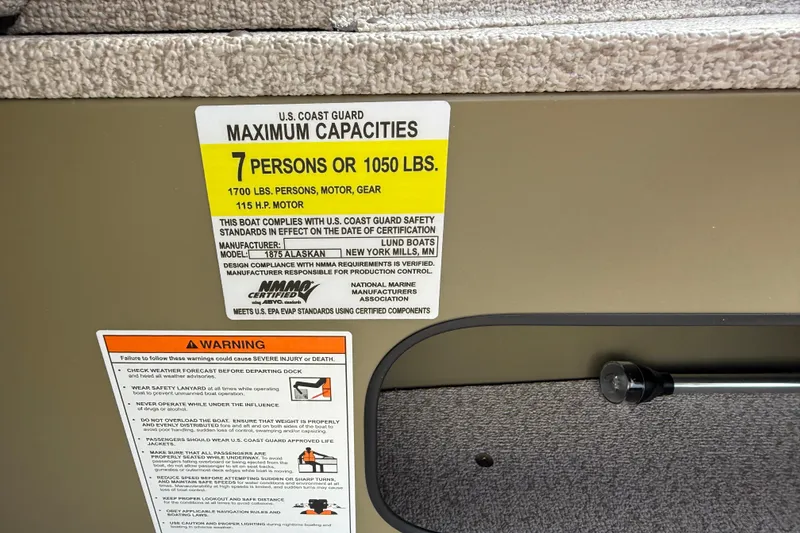Slide: The Image of 2025 Lund 1875 Alaskan SS boat capacity label, 7 persons or 1050 lbs, safety warnings. - 21