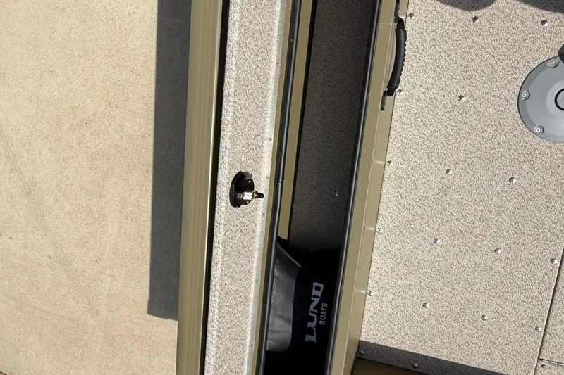 Slide: The Image of 2025 Lund 1875 Alaskan SS boat interior with storage compartment and textured flooring. - 23