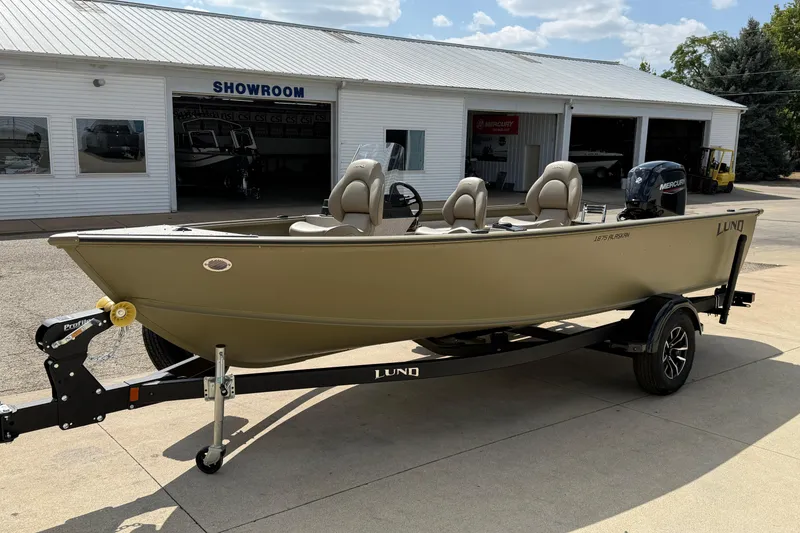 Slide: The Image of 2025 Lund 1875 Alaskan SS boat on trailer outside showroom, sunny day. - 4
