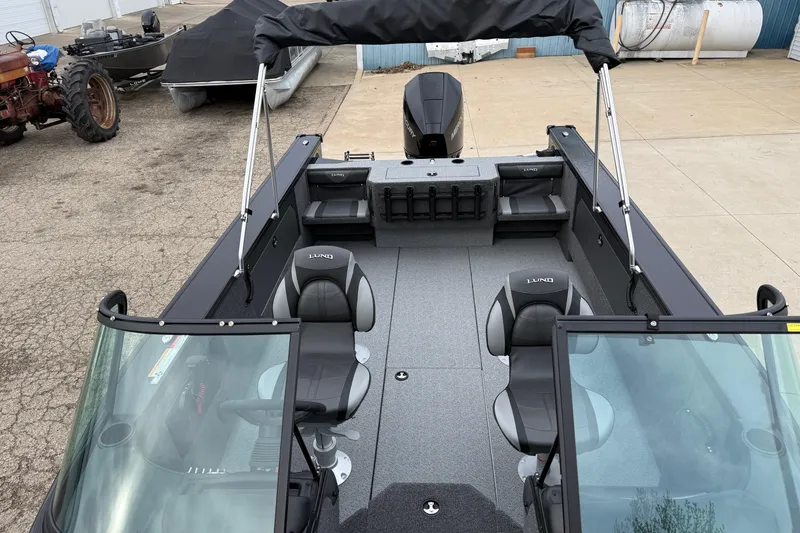 Slide: The Image of 2026 Lund 2075 Fisherman boat with seating and canopy, parked outdoors. - 13