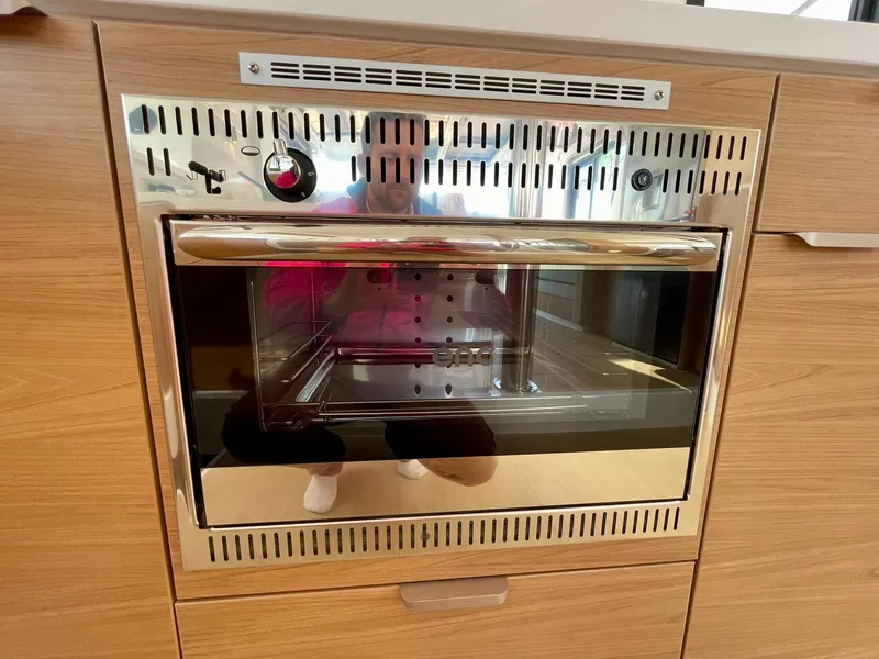 Slide: The Image of Modern Bali 4.2 oven, 2026 model, with stainless steel finish and wooden cabinetry. - 10