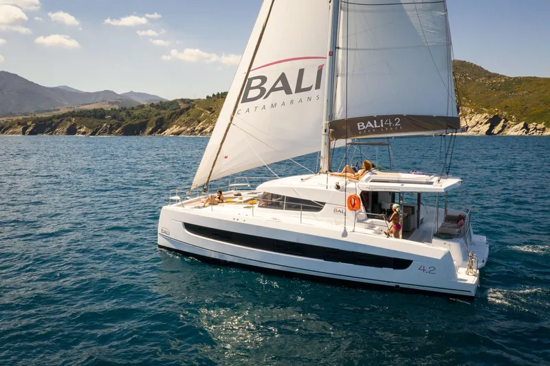 Slide: The Image of 2026 Bali 4.2 catamaran sailing on blue ocean near scenic coastline. - 49