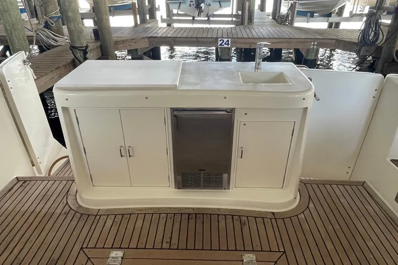 Slide: The Image of 1999 McKinna 57 Pilothouse yacht docked, featuring wooden deck and "Aventis" name. - 15