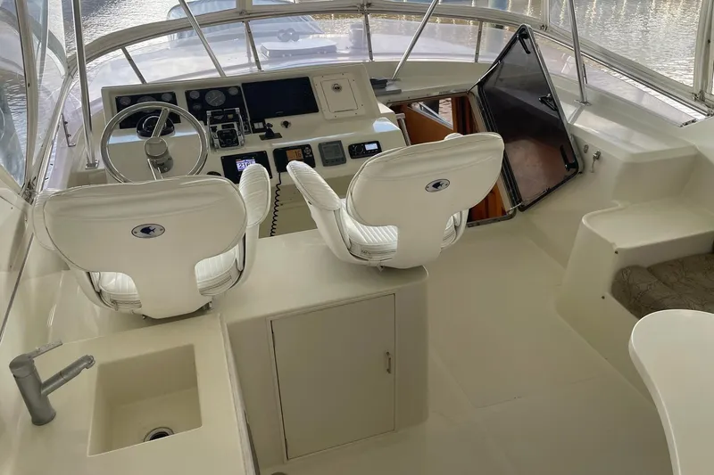 Slide: The Image of 1999 McKinna 57 Pilothouse interior with mini fridge and seating area. - 18