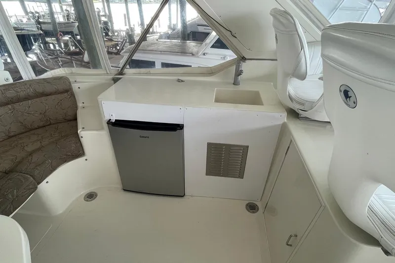 Slide: The Image of Interior view of 1999 McKinna 57 Pilothouse yacht with seating and marina backdrop. - 19