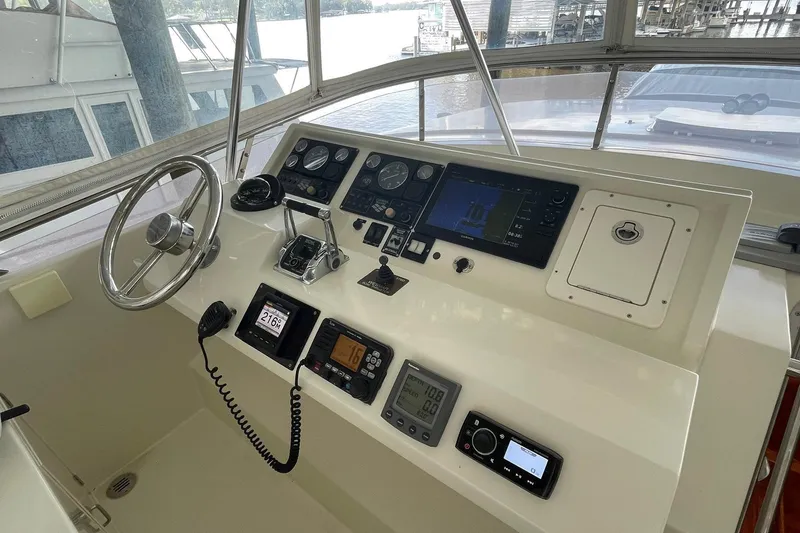 Slide: The Image of 1999 McKinna 57 Pilothouse interior with curved seating and white captain chairs. - 23