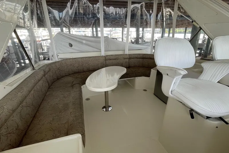 Slide: The Image of 1999 McKinna 57 Pilothouse helm with white captain chairs and control panel. - 24