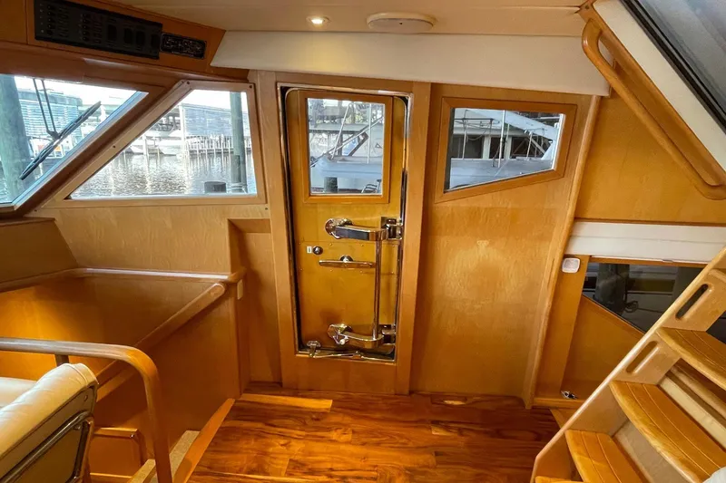 Slide: The Image of Luxurious interior of 1999 McKinna 57 Pilothouse yacht with wooden accents and plush seating. - 34