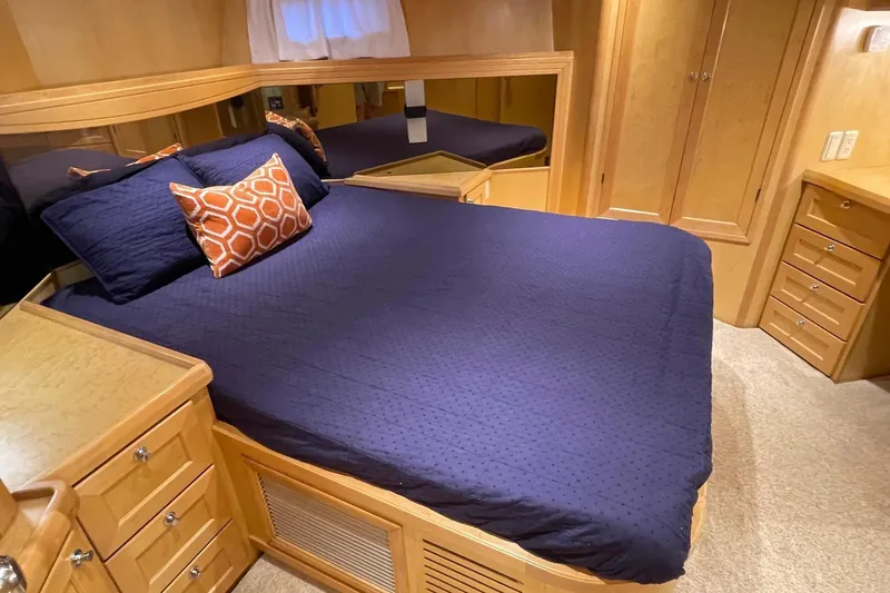 Slide: The Image of Luxurious 1999 McKinna 57 Pilothouse bedroom with wooden cabinetry and blue bedding. - 42
