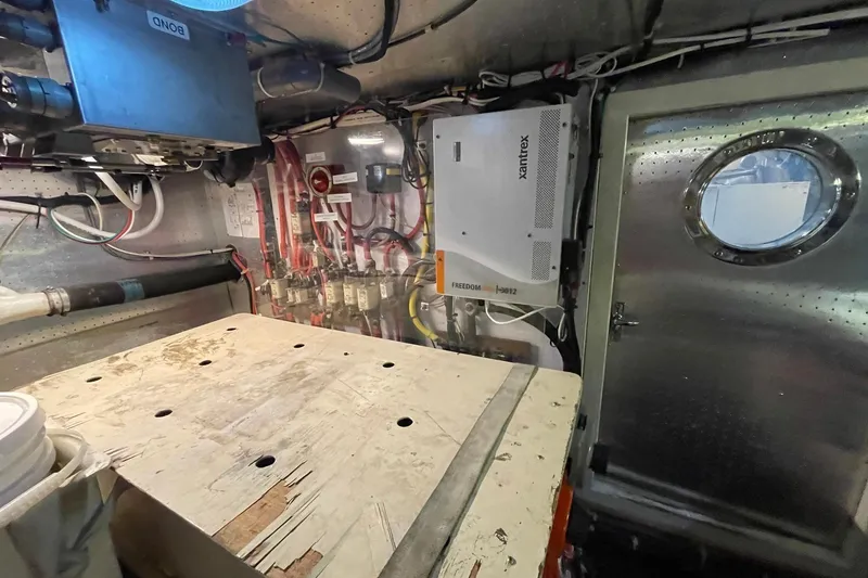 Slide: The Image of Engine room of a 1999 McKinna 57 Pilothouse yacht, featuring equipment and wiring. - 62