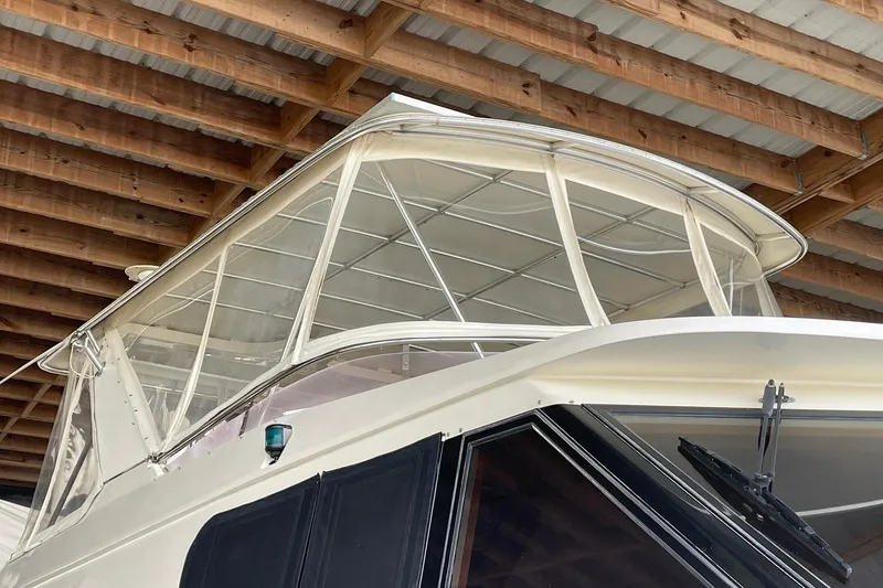 Slide: The Image of 1999 McKinna 57 Pilothouse yacht docked under a wooden shelter. - 9