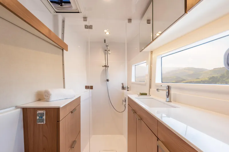 Slide: The Image of Modern yacht bathroom interior with wooden cabinets, sleek fixtures, and large window, Bali CATSMART 2026. - 22