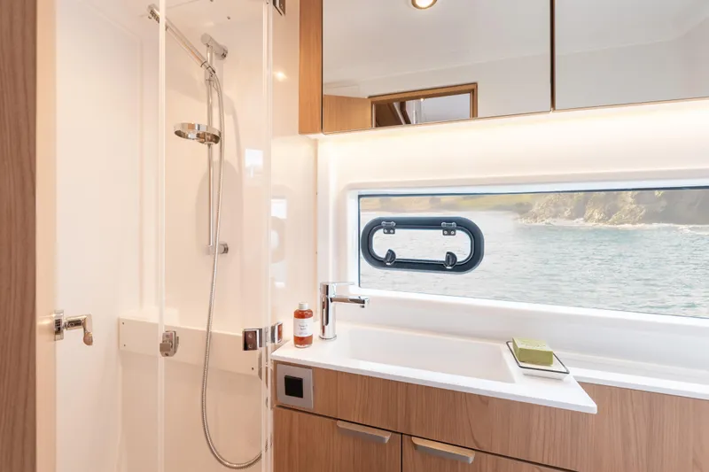Slide: The Image of Modern yacht bathroom with shower, wooden cabinetry, and ocean view window in Bali CATSMART 2026 model. - 26
