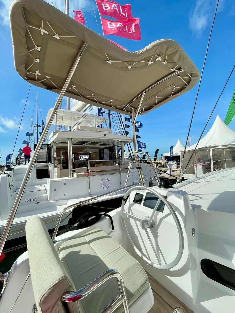 Slide: The Image of 2026 Bali CATSMART boat with canopy and steering wheel, displayed at a marina under blue skies. - 28