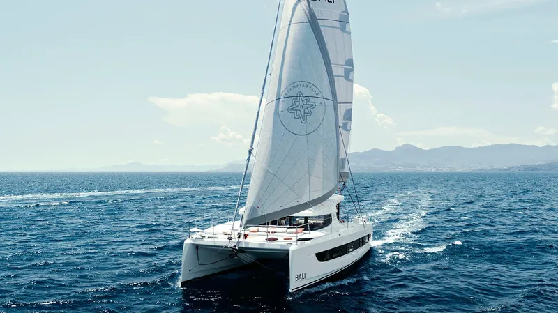 Slide: The Image of Sailing catamaran Bali CATSMART 2026 on open sea with clear skies. - 7