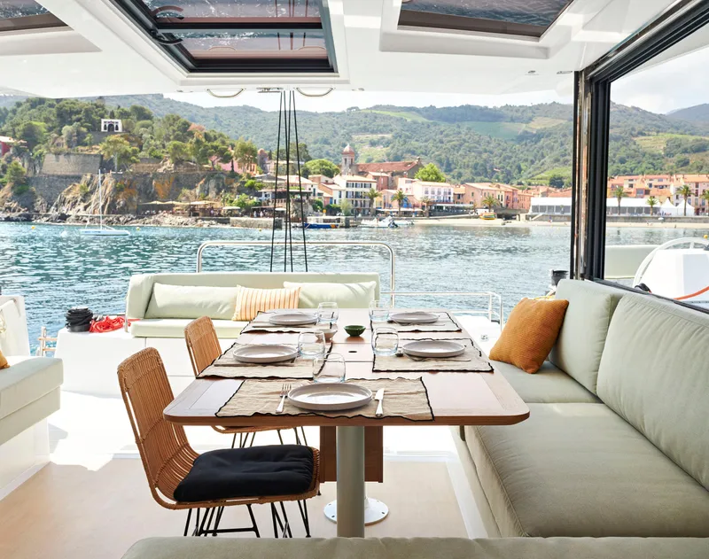 Slide: The Image of Luxurious Bali CATSMART 2026 yacht interior with elegant dining setup, scenic coastal view. - 9