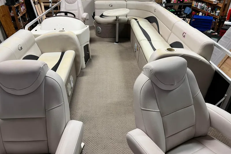 Slide: The Image of 2014 Avalon Grand Island 2485 QF pontoon boat interior with plush seating and helm. - 2
