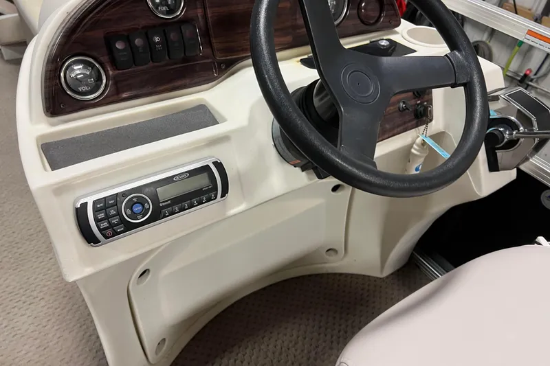 Slide: The Image of 2014 Avalon Grand Island 2485 QF boat dashboard with steering wheel and control panel. - 28